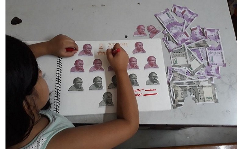 child's creative work using 500 rupee notes (Gandhiji's photos)